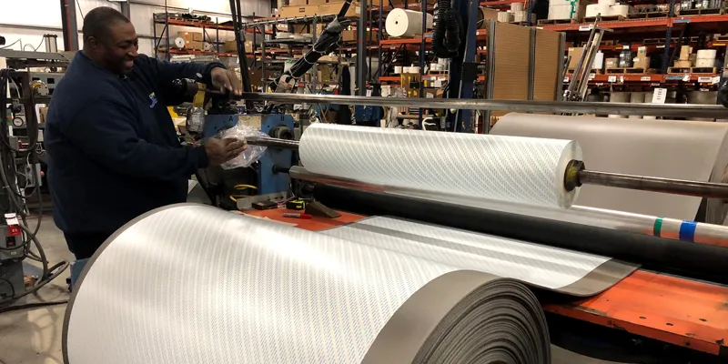 An expert team member at JBC Technologies using a mill roll to help eliminate converting challenges for a customer.