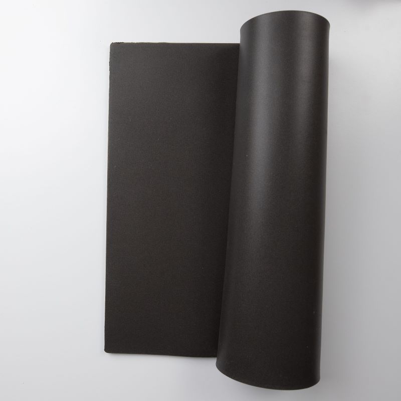 Black fabric, partially rolled on a cylindrical spool, with a portion laid flat beside it.